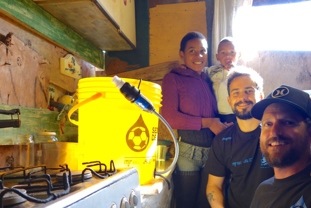 Jon Rose, Guga Ketzer and Jessica after they just gave her access to clean drinking water in favela Jardim Itapema in 2014 | © Red Bull