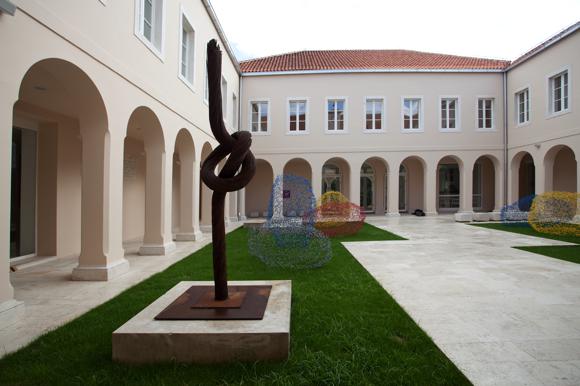 Colonnaded courtyard area at the Split Gallery of Fine Arts, which is occupied by several abstract sculptures made of wire mesh.