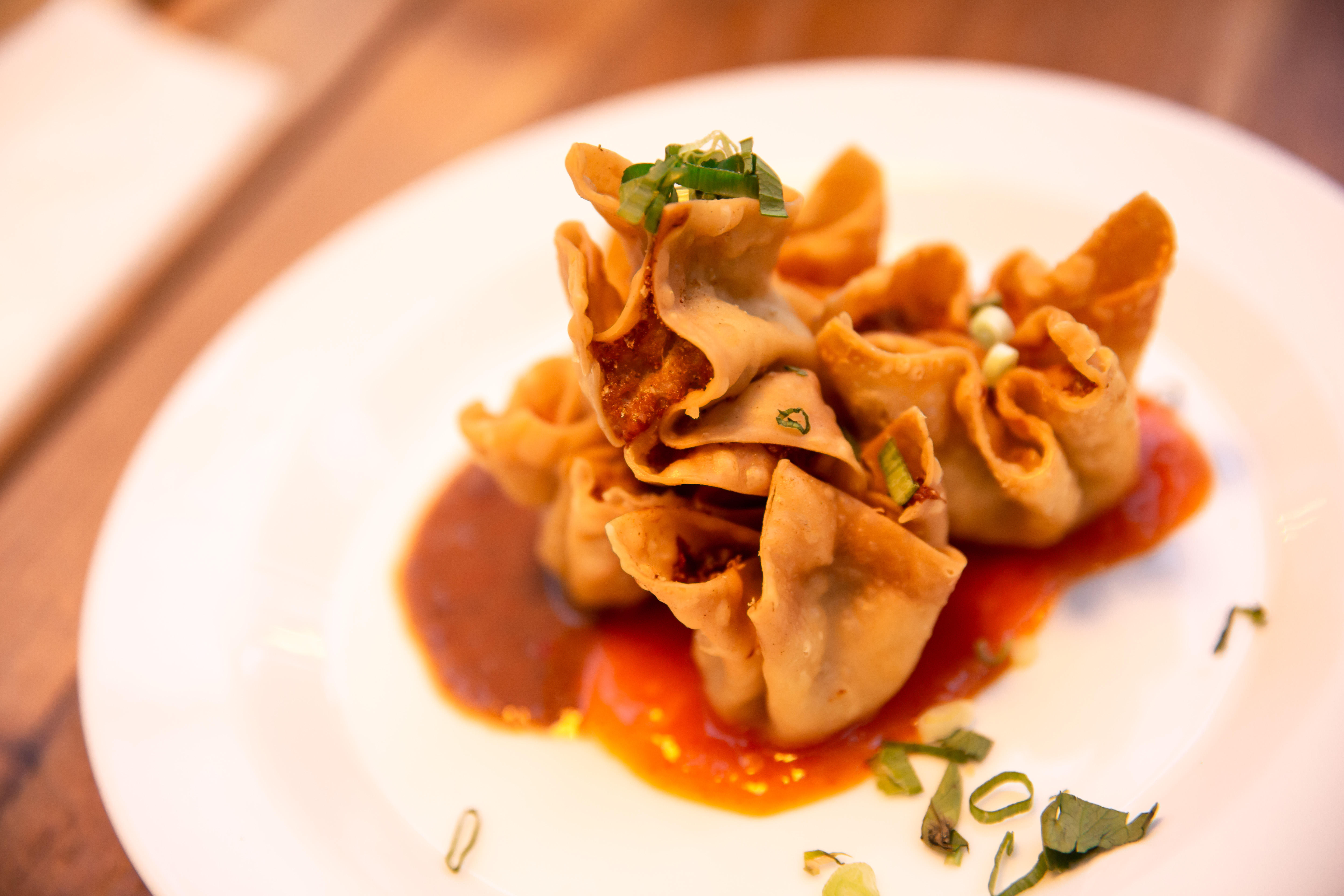 Sundanese Indonesian traditional food Fried Dumplings (Batagor) with peanut and chilli sauce on a white plate