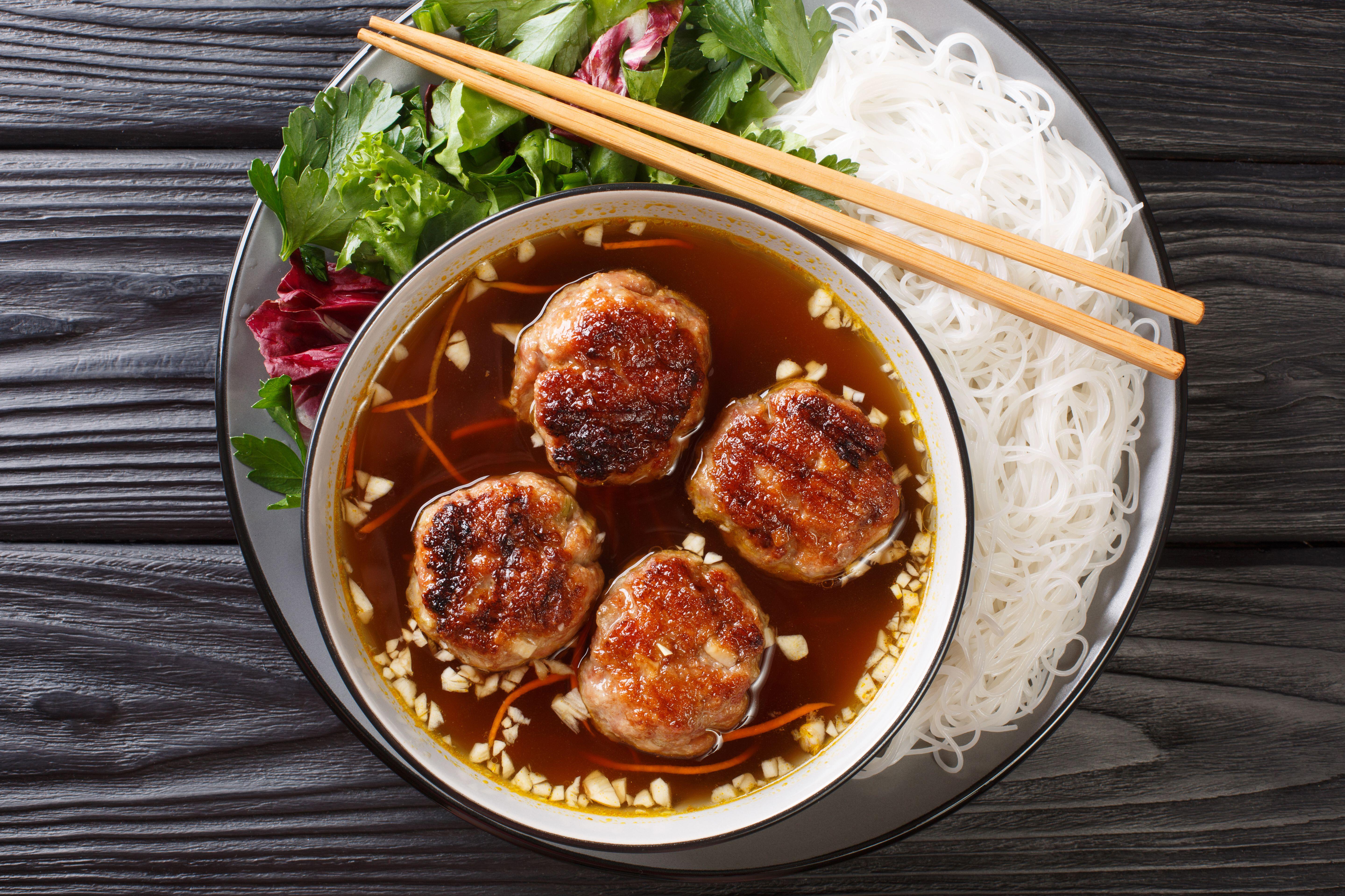 Bun cha Hanoi is a delicious Vietnamese street food combining flavorful meatballs, rice noodles and a tangy dipping sauce. Horizontal top view from ab